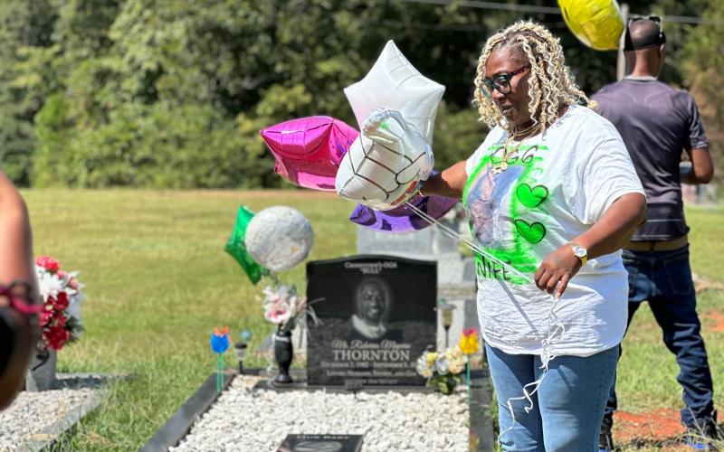 Crystal Thornton (left), the wife of the late Roberius Thornton who was shot and killed in an altercation at a local nightclub two years ago, hosted a balloon release at her husband’s grave site Sept. 2. Thornton is still searching for answers regarding her husband’s death, which remains and unsolved crime.
