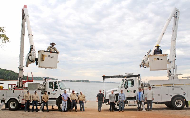 Hart County is serviced by two companies  for their electricity needs. On the left, is a crew from Georgia Power including (from left to right): Ethan McCleery (Apprentice lineman), Clarke Looney (supervisor), Freddy Arteaga (apprentice lineman), Jayson Summers(engineer), Mitch Turpin (lineman), Keith Vickery (lineman), and the bucket is Vladimir Flor-Huerta (apprentice lineman). On the right is a crew from Hart EMC including: David Craft, Jared Dove, Sam Findley, Joey Fowler, Caden Hart , and Shaun Martin