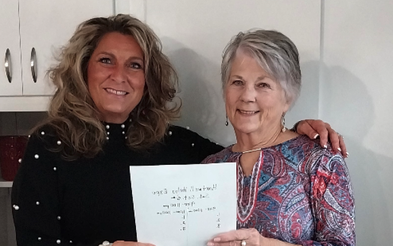 Linda Gunter (left), CEO and Co-founder of Love Him Love Them stands with Claudia Kay, Local Assistance Coordinator as they look over details for their Thanksgiving event.