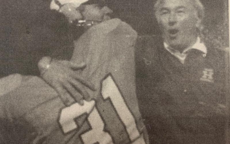 From left: Tracy Curry (31), Coach Bill Bonds, and Coach Bobby Pate celebrate after a touchdown.
