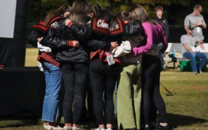 A group of Hart County Cheerleaders pray with head cheer coach Mollie Payne at Fields of Faith 2023. Photo by Lexie Wheless.