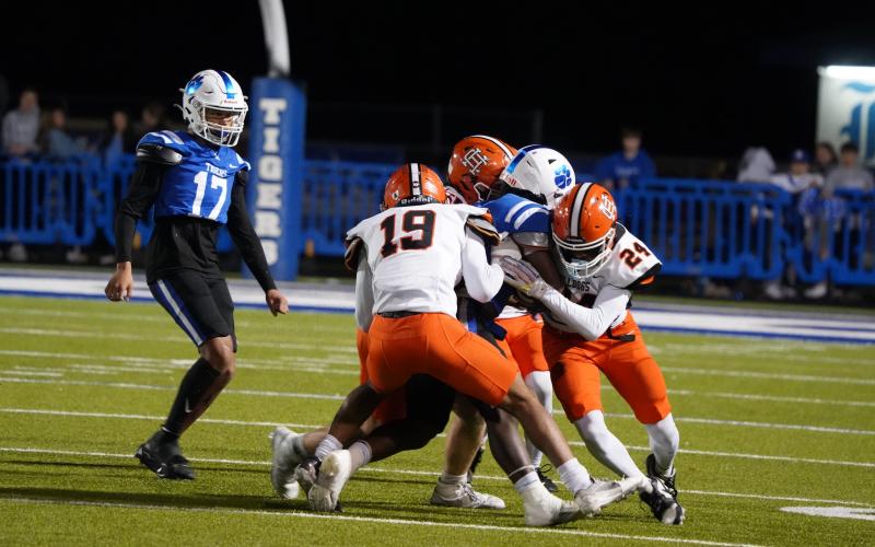 A host of Dog defenders make the tackle on a Tiger running back. Photo by Greg Gaines.