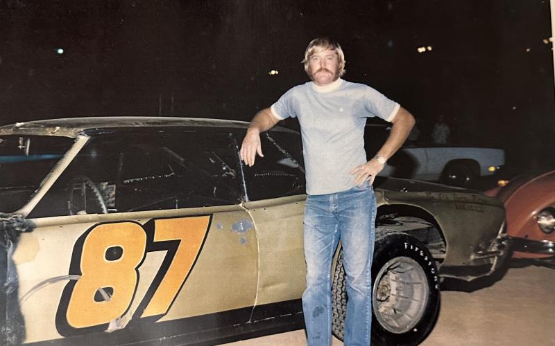 Frankie Carnes, standing next to his race car, around the time of his disappearance in the 1970s.