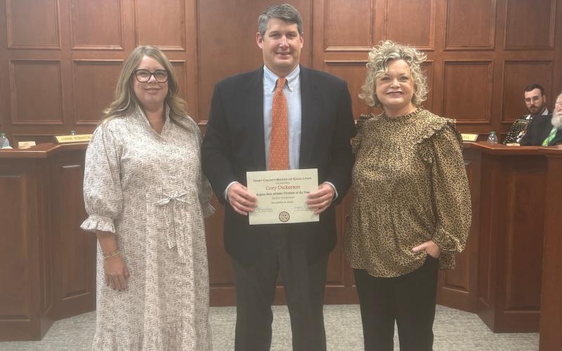 Hart County athletic director and head football coach Cory Dickerson (middle) was honored at the Board of Education meeting on Dec. 9. Also pictured is Kim Pierce (left) and superintendent Jennifer Carter (right).