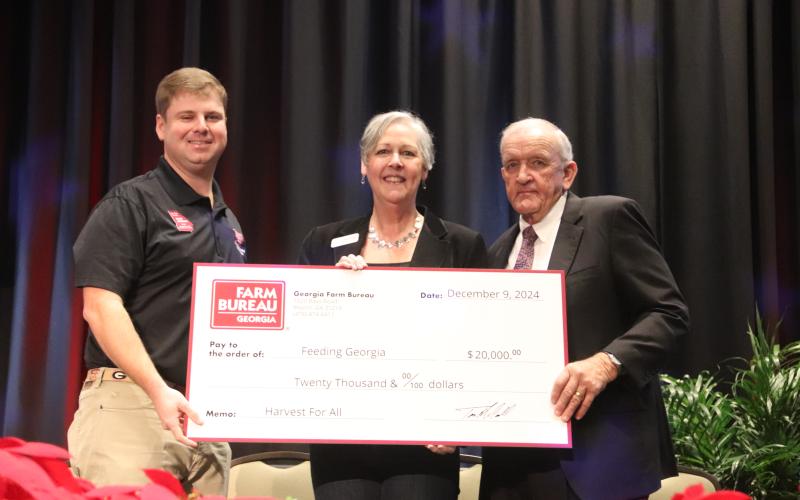 2024 Georgia Farm Bureau Young Farmer Committee Chair Cleve Jackson, left, and GFB President Tom McCall, right, present a check for the proceeds of the 2024 Harvest for All campaign to Georgia Food Bank Association Executive Director Danah Craft (center) during the 2024 GFB Annual Convention on Jekyll Island. Photo courtesy of Georgia Farm Bureau.