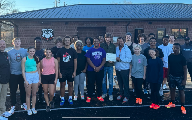 Assistant Superintendent Brooks Mewborn (far left), stands with the Hart County High School track and field team in front of the new multi-purpose athletic building at Veterans Stadium.