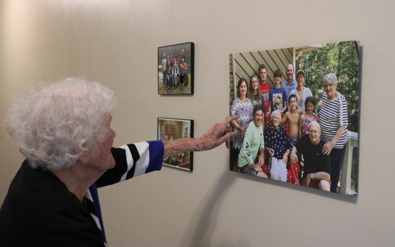 Mahannah admires her family photo displayed in her bedroom at Brookdale Senior Living. She has sewn for her children and grandchildren their entire lives. (Photo/Adriana Cascio)