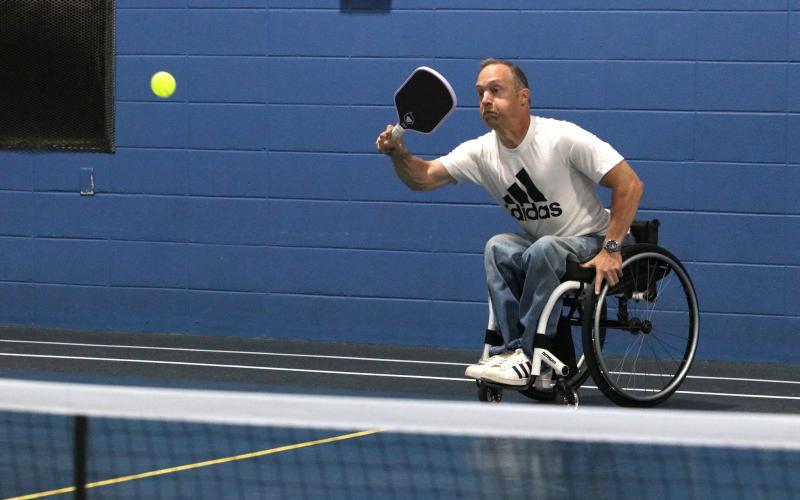 Phillip Henderson, 51, strikes a pickleball while maneuvering his wheelchair at the YMCA on Monday. Henderson, paralyzed at 14, has played sports his entire life and continues to exercise almost daily. (Photo/Adriana Cascio)