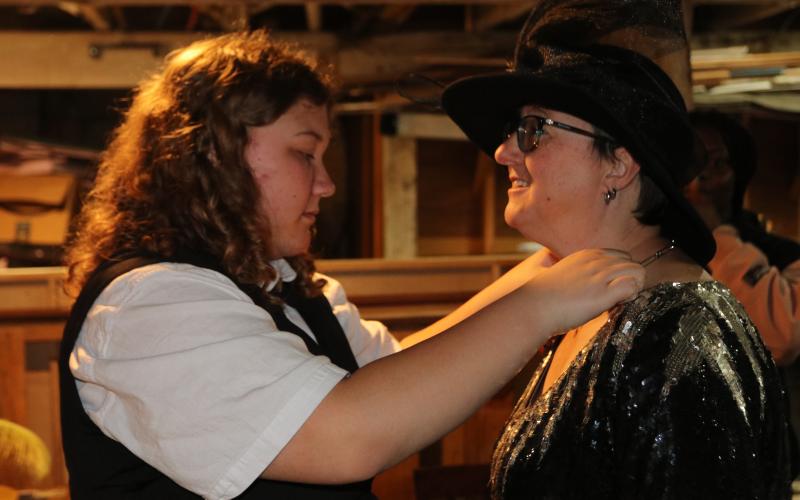 Peyton Woodall, Hart County High School student, puts a necklace made from safety pins on Lani Sessoms, Hart County Community Theatre president, for a Lydia Deetz costume at Backstage Experience Day. At the “costumes” station, students had the opportunity to design costumes and practice quick costume changes with Sessoms and Kara Holden, Hart County Community Theatre member. (Photo/Adriana Cascio)