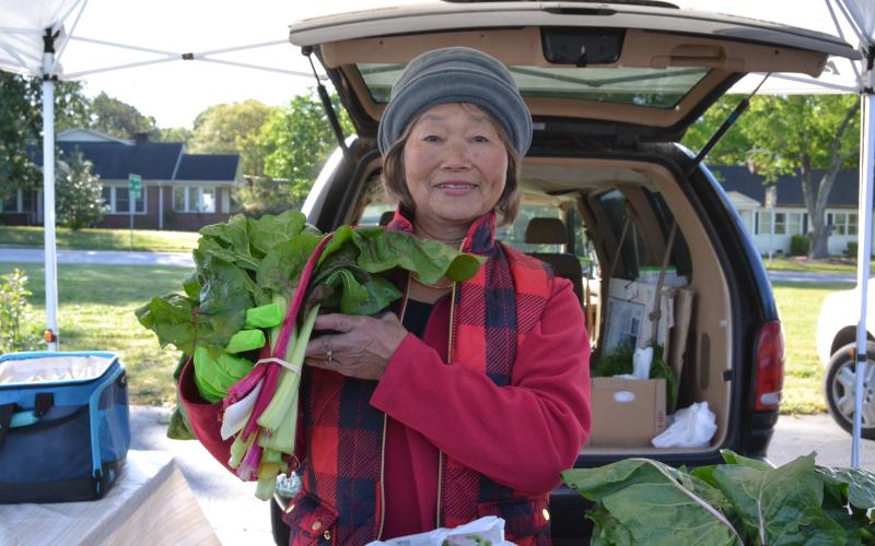 May Workman holds homegrown swiss chard during the opening weekend of the Hartwell Farmers Market April 12. Workman has been selling at the market for 22 years and sells berry plants, greens, carrots and other vegetables. (Photo/Adriana Cascio)