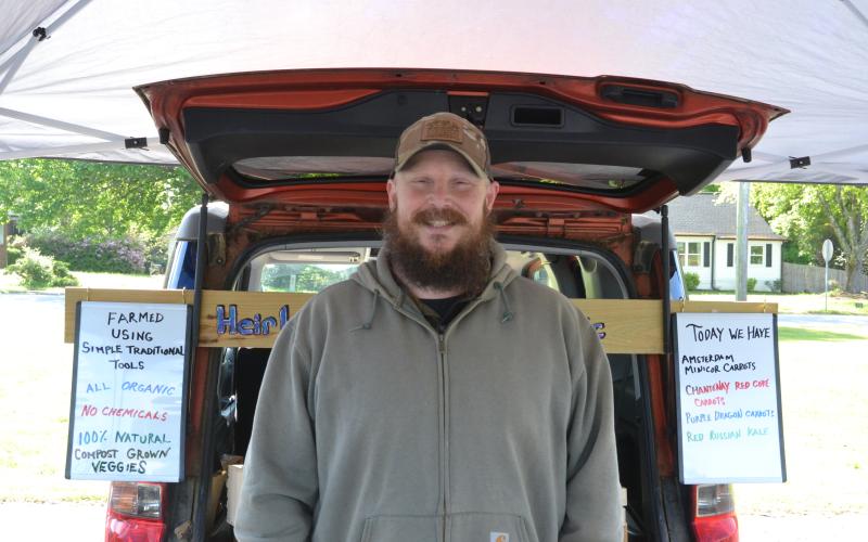 Nick Wasley, owner of Little Friends Farmstead, stands in front of his booth during the opening weekend of the Hartwell Farmers Market April 12. Wasley has been selling at the market for three years and values all natural, traditional farming methods. (Photo/Adriana Cascio)