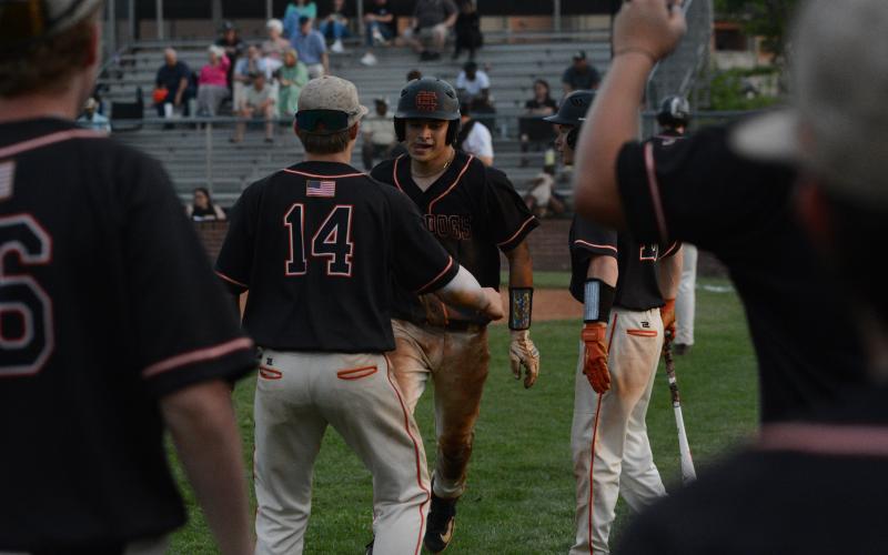 Senior catcher Pearce Mewborn (right) celebrates with freshman Slate Osborne (14) after scoring a run against Thomson in the first round of the state playoffs. (Photo/Benjamin London)