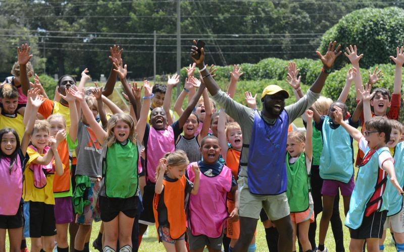 Pictured is YMCA’s sports director Kerv Augustin and kids during a soccer camp back in the summer of 2023. (Photo/Benjamin London)