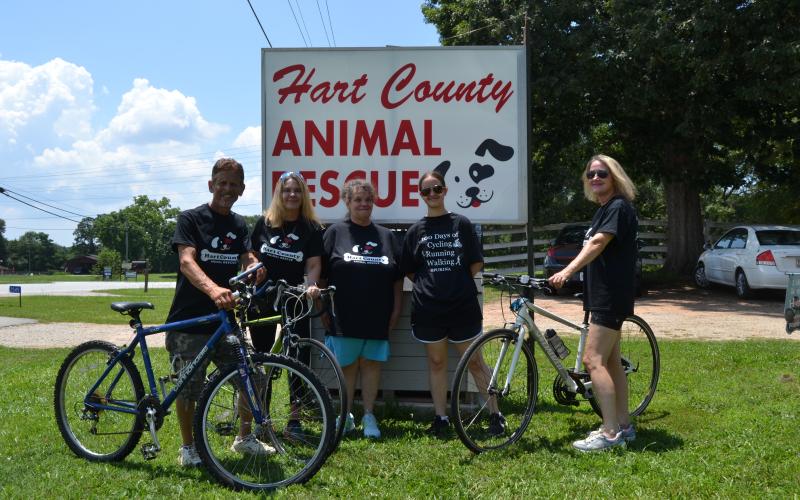 Hart County Animal Rescue (HCAR) employees and volunteers (L-R) Robert Sterling, Kristi Sterling, Sherri Lane, Maycee Lane and Lisa Oliphant pose with bicycles in front of the HCAR sign. The group is participating in 100 days of walking, running and cycling to raise awareness for the organization and struggling dogs in the Hart community. (Photo/Adriana Cascio)