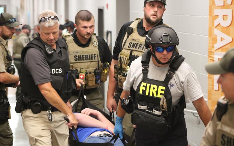 First responders carry a student actor out of the building during an Emergency Response Drill on Aug. 1 at Hartwell Elementary School. (Photo/Grayson Williams)