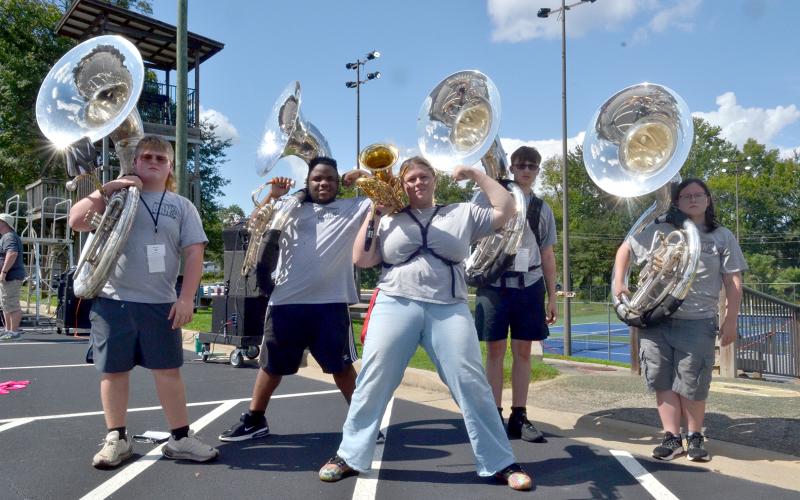 Sousaphonists (L-R) Kabil Carey, Jaylin Jones, Jaxon “Bart” Harris and Abie Kershner stand behind baritone saxophonist Bri Isbell after being named section of the week for this week’s High Notes series. Leaders noted this section’s hard work in learning drill and music, as well as their fundamental importance in the band. (Photo by Adriana Cascio)