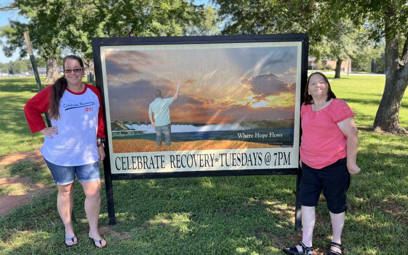 Minister leader Stephanie Carey (left) and volunteer Tammy Lampp (right) pose in front of the Celebrate Recovery sign outside of Cornerstone Baptist Church, located at 1543 Anderson Highway. Celebrate Recovery is a program dedicated to servicing those recovering from drugs, alcohol, depression, overeating and other addictions. (Photo submitted by Stephanie Carey)