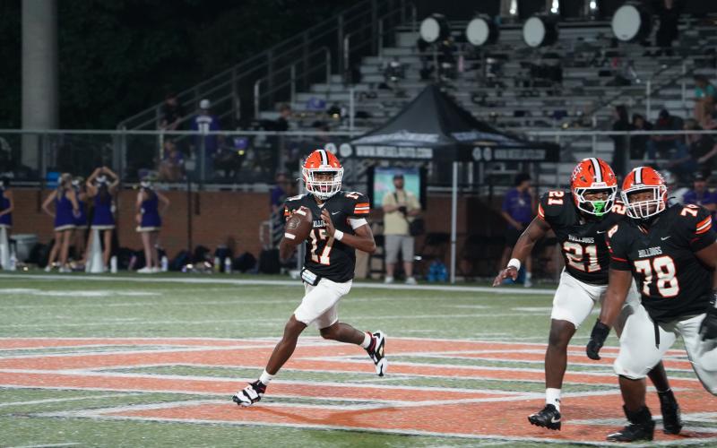 Junior quarterback Kurston Curry rolls outside the pocket to throw on the run during the 19-14 loss to Lumpkin. (Photo by Ric Williams)