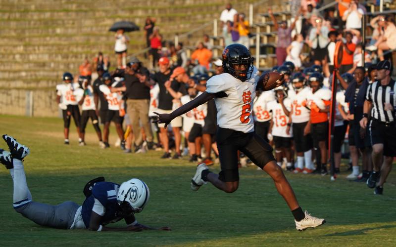 Trey Rucker as he stiff arms a defender on his way into the endzone. (Photo by Ric Williams)
