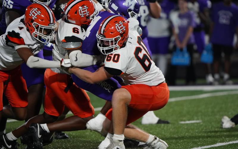 A host of Dogs defenders bring down the Monroe Area running back in the 25-13 loss Sept. 19. (Photo by Ric Williams)
