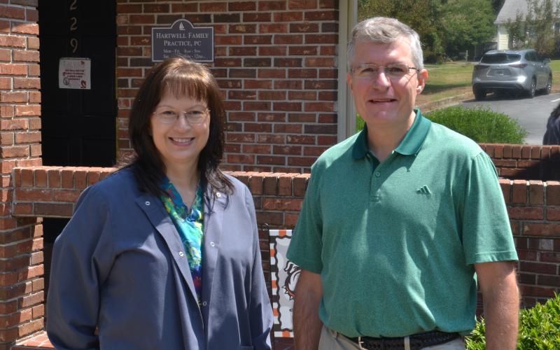 Nurse Lisa Walters (left) and Dr. JoDon Garringer (right) pose together in front of Hartwell Family Practice, located at 229 Athens St., on Sept. 3. Garringer said he and Walters have developed a brother-sister relationship, after watching their families and careers grow alongside each other. (Photo by Adriana Cascio)