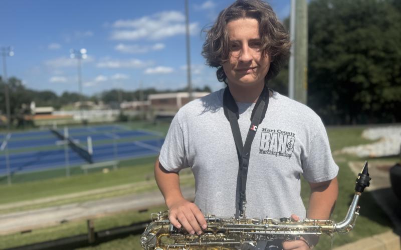 Sophomore saxophonist Henry Waters smiles and holds his instrument at attention after being named member of the week for this week’s High Notes series. Waters was not only recognized for his ability to stay in step, but also for always moving the band’s equipment. (Photo by Adriana Cascio)