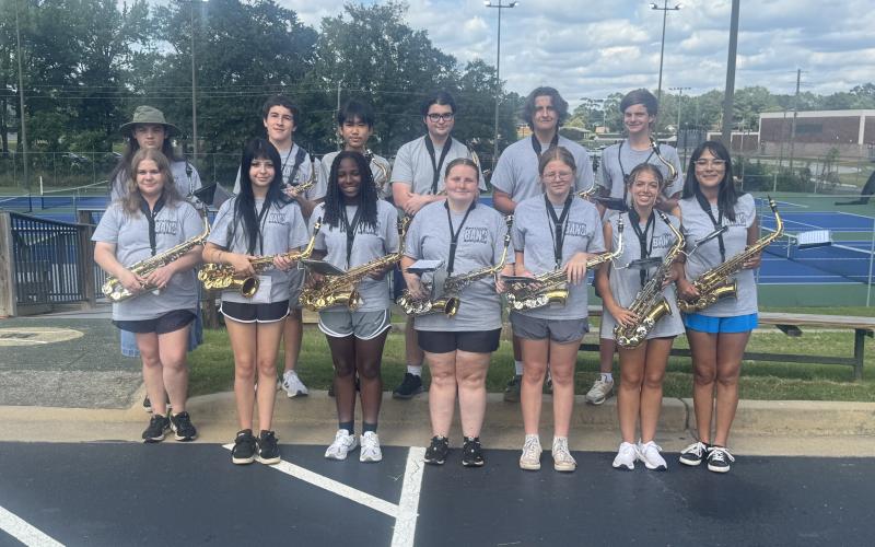 Saxophonists (front row, L-R) Breanna Carruth, Sophie Waldron, Tori White, Brianna King, Abigail Pressley, Ava Shiflet and Camila Hernandez; and (back row, L-R) Harper Sims, Jorge Aguilar, Johnson Dang, Brent Vickery, Henry Waters and Henley Skelton stand together after being named section of the week for this week’s High Notes series. Vickery, section leader, said his section has improved in every area of marching and continued to grow since band camp. (Photo by Adriana Cascio)