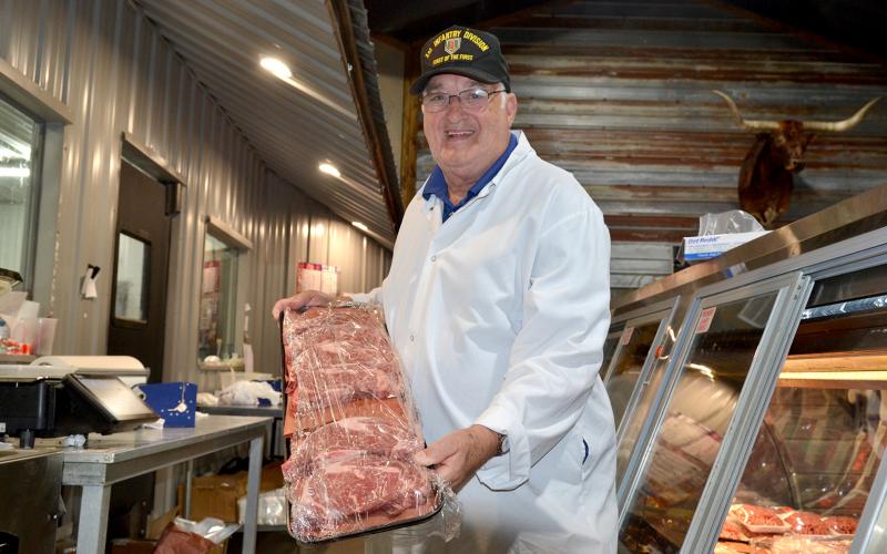 Winston Phillips, who has spent nearly six decades working in five different butcher shops, presents a tray of ribeyes, his favorite cut of meat, at Hometown Butcher.  (Photo by Adriana Cascio)