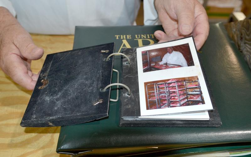 Anne Phillips, his youngest daughter, created a book filled with small photos of her father at Bell’s Food Store, showing him with piles of bright red beef, butcher knives, packaged pig feet and even his smiling granddaughters in the meat aisle. The cover highlights Winston Phillips’s three defining roles: meat cutter, military sergeant and father. (Photo by Adriana Cascio)