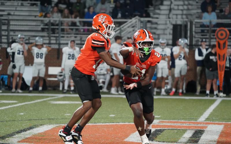 Junior quarterback Kurston Curry (left) fakes the hand off to his junior running back Faustino Rangel (right) before running a quarterback keeper in the 21-6 win over the Eagles of East Jackson Oct. 17. (Photo by Ric Williams)