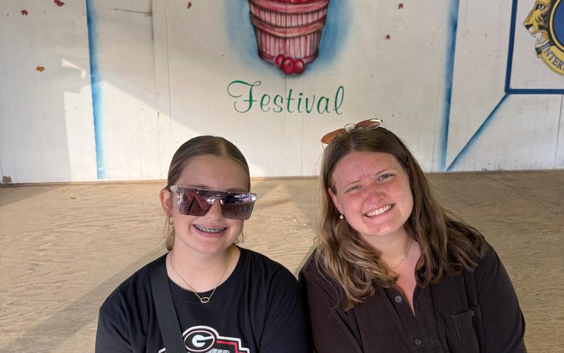 The final stop on our grand fall adventure Saturday was Ellijay’s Georgia Apple Festival. My cousin, Chloe Peace (left), and sister, Marlie Scoggins (right) posed for a photo in front of the festival stage. (Photo by Rose Scoggins)