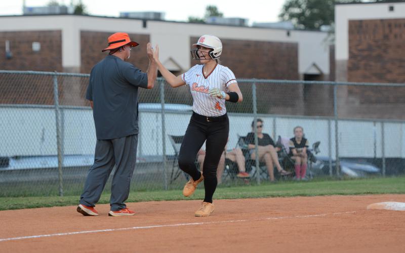 Senior infielder Madi Bennett rounds third and high fives Lady Dogs head coach Gerald Gates after hitting a solo home run en route to a 7-4 win over the Lady Tigers of Commerce Oct. 8. (Photo by Benjamin London)