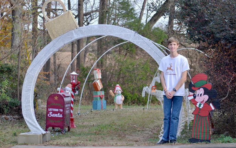 Hart County High School 11th grader Tyler Bowers stands in front of the entrance to his light display on Cedar Creek Circle. The display celebrates a decade of bringing Christmas cheer to the community.