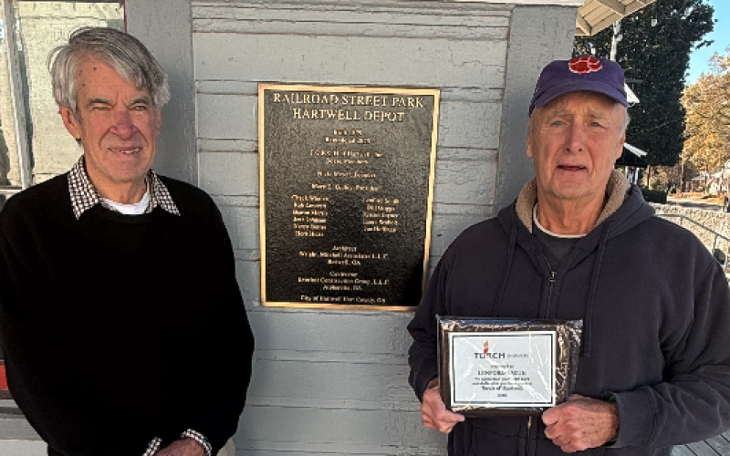 TORCH board member Larry Torrence (left) surprised outgoing fellow board member Lenford Smith (right) with a plaque for his years of service to the board. Photo by Rose Scoggins.