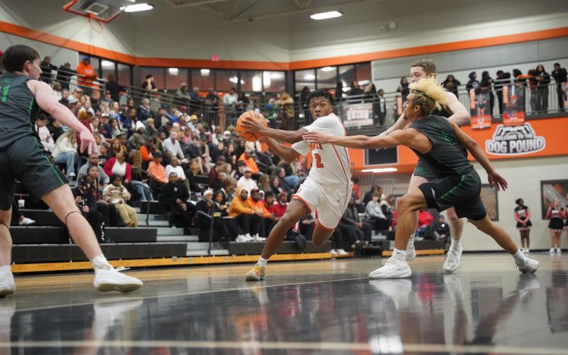 Senior guard Zaylen Shealer (left) drives to the basket against two Lion defenders, as he scores a career high 32 points in the 89-61 win over Franklin County Jan. 20. Photo by Ric Williams.