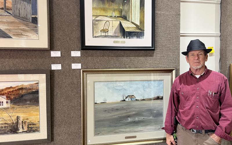 Stan O’Bannon stands next to his works at the Hartwell Art Center. His exhibit will kick off with an opening reception tonight and will be open through March 21. Photo by Madison Linton.