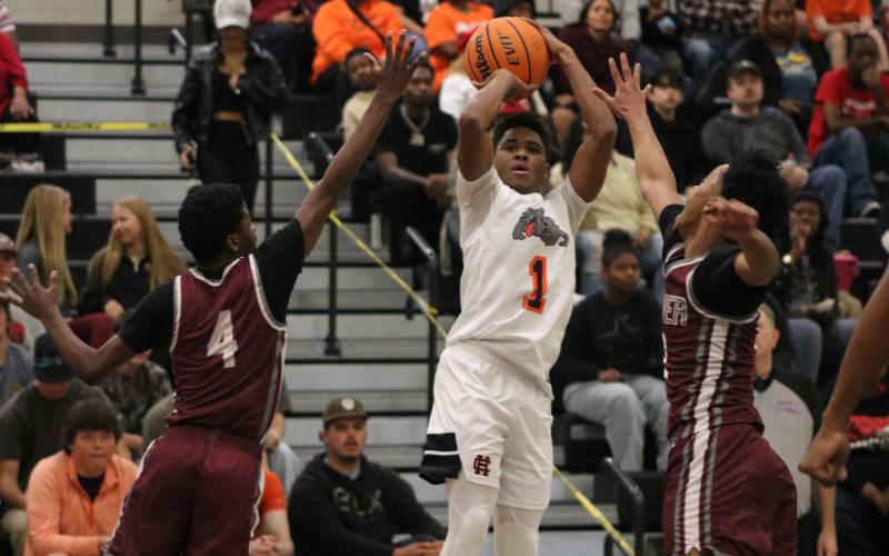 Junior guard Kurston Curry drains a three in the face of multiple defenders, as he tied his career high scoring 32 points in the 89-72 win over the Panthers of Carver (Atlanta) Feb. 28. Photo by Grayson Williams.