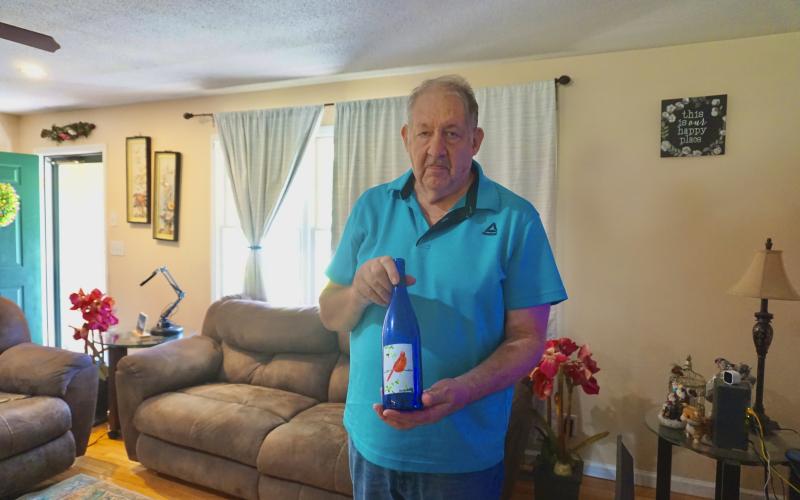a bottle he painted with a cardinal. Those interested in purchasing any of Meth's artwork can stop by the home or contact him at 706-436-8576.  Photo by Madison Linton