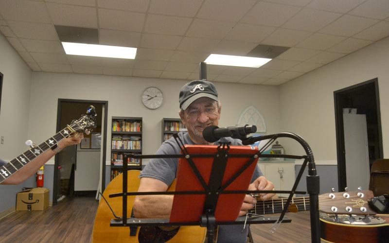 Richard Frady looks at the lyrics of a song on his tablet during the performance.  Photo by Madison Linton.