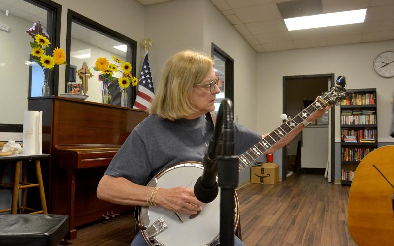Jo Ann Moore strums her banjo during a performance. Photo by Madison Linton.