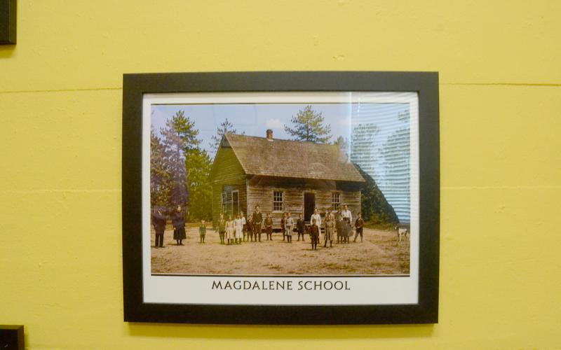 The Hart County Museum is located at 31 E. Howell St., in the Teasley-Holland House. Inside, museum-goers will find old artifacts donated from the public, such as the book Hart County Historical Society board chair Allen Stewart holds. They can also find AI-generated reworks of real, old photographs from Hart County's pre-consolidated schools and churches that allow them to be colorized and showcase similar-appearing people. Photo by Madison Linton.