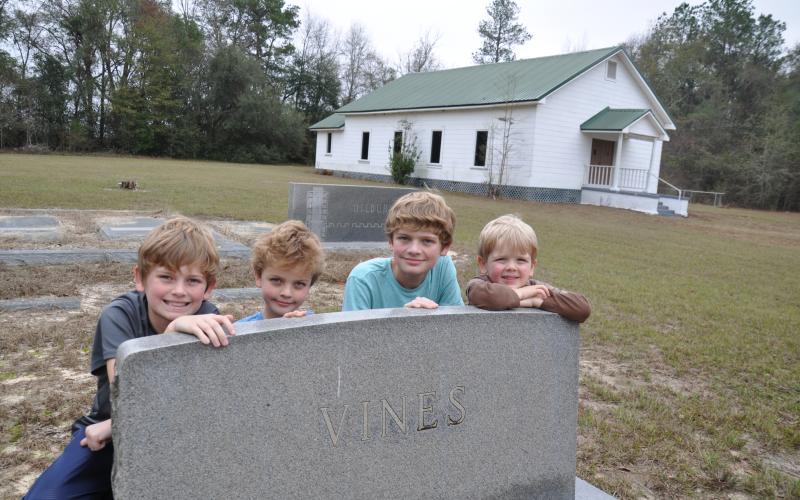 In 2017 four of our eight grandchildren visited the graves of their ancestors at Pilgrims Home Free Will Baptist Church on Hwy. 91 in Baker County, Georgia. The Wilsons are, from left, Hayes, Henry, Wyatt and Smith. They are posing by the granite tombstone of my mother’s parents, Howell and Essie (Nanny) Vines. Photo submitted by Dink NeSmith.
