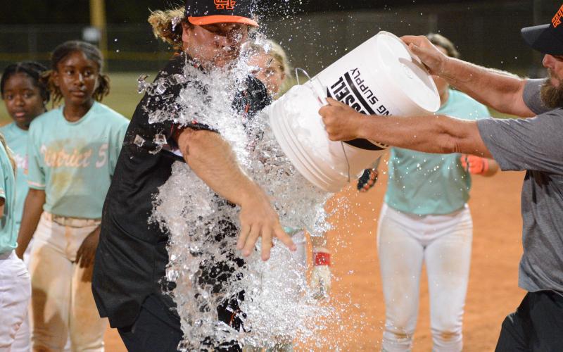 Hart County Little League’s president and the Senior League softball team’s manager Mason Bowers receives a ice bath after capturing their fourth straight state title to advance to the Southeast Regional July 24-27. Photo by Benjamin London.
