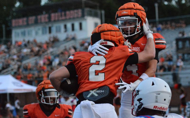 Senior wide receiver Knox Pierce (2) celebrates with teammates Crew Franklin (right) and Kurt Curry (left) after scoring the opening touchdown of the game in the 49-0 win Aug. 7.  Photo by Benjamin London.