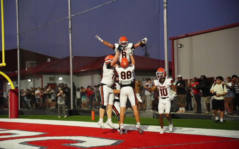 Offensive players celebrate with senior running back Kaidyn Allen (8) after scoring from 14 yards out, as the Dogs advanced to 2-0 with a 51-12 win over the Red Raiders of Madison County Aug. 28. Photo by Ric Williams.