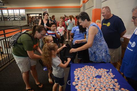 Hartwell Rotary Club member Ganine Derleth gives hand sanitizer to Elektra Head, 7, and her sister Ziva Head, 5, while their mother Kimberly Head helps and club member Mike Everett, standing at right, looks on.