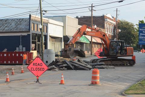 Sunshot by Michael Hall — Heavy machinery breaks up the asphalt at the corner of Forest Avenue and Depot Street on Tuesday as work continues on a major infrastructure improvement project underneath Depot Street. 