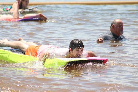 Sunshots by Grayson Williams — Carter Reed navigates his paddle-board style boat past band director Alan Tolbert, right, who officiated the event from the water. 
