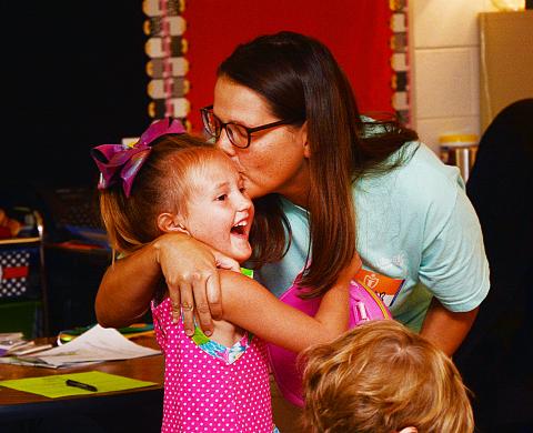 Sunshots by Michael Hall Jantzen Carter, above, kisses her daughter Lailan, 5, before leaving her with her teachers and classmates on the first day of school on Aug. 1 at North Hart Elementary School. 
