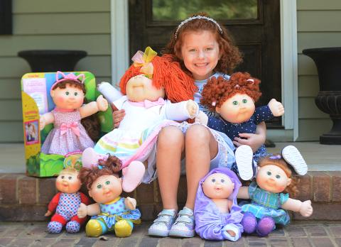Sunshot by Michael Hall — Lainey Moon poses for a photo with her Cabbage Patch dolls, including the one she won in a look-alike contest she holds in her right hand. 